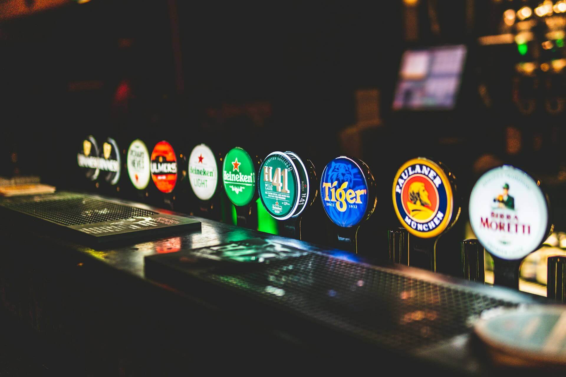 Beer taps in a bar, various brands visible.